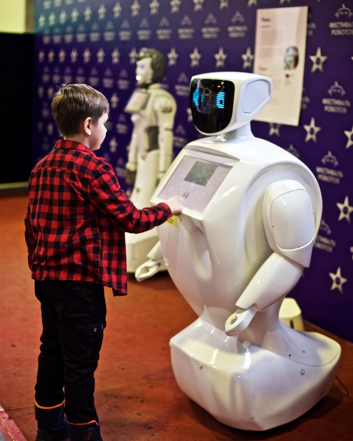 Young boy is contacting with the robot